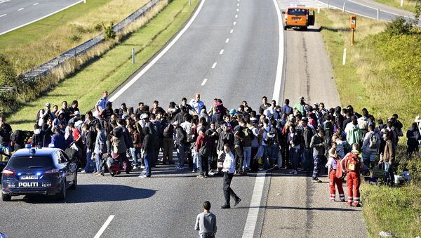 A group of refugees and migrants who were walking north stand on the highway in southern Denmark on Wednesday, Sept. 9, 2015 - Sputnik International