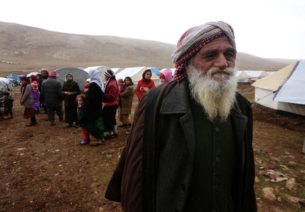 Displaced Iraqi people from the Yazidi community, who fled violence between Islamic State (IS) group jihadists and Peshmerga fighters in the northern Iraqi town of Sinjar, gather around their tents at a refugee camp set up on Mount Sinjar on January 15, 2015. Displaced Iraqi people from the Yazidi community, who fled violence between Islamic State (IS) group jihadists and Peshmerga fighters in the northern Iraqi town of Sinjar, gather around their tents at a refugee camp set up on Mount Sinjar on January 15, 2015. - Sputnik International
