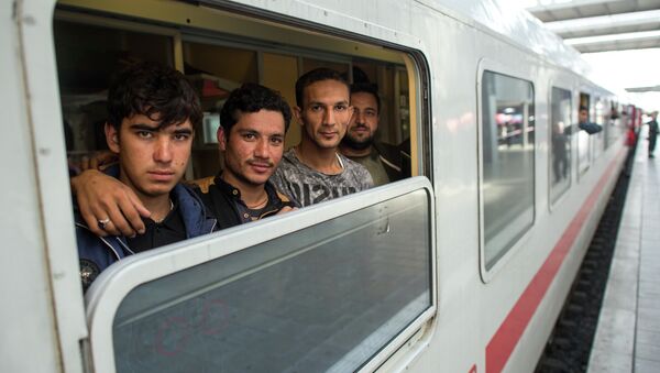 Friends Ibrahim, Hamayoun and Nomi, from left, refugees from Afghanistan, travel in a special train to Dortmund, photographed at the central train station in Munich, Germany, Friday Sept. 11, 2015. - Sputnik International