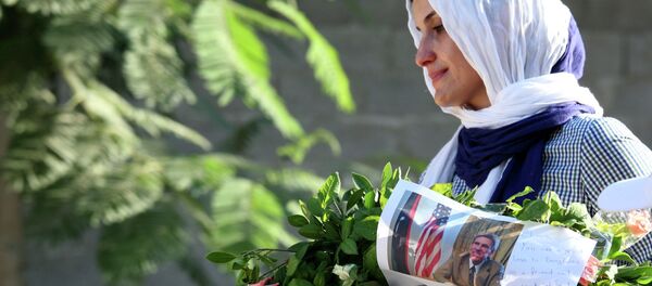 Libyan woman carries a wreath with a photo of U.S. Ambassador Chris Stevens on it as she and others gather to pay their respect to the victims of the Tuesday, Sept. 11, 2012 attack on the U.S. consulate, in Benghazi, Libya, Monday, Sept. 17, 2012 Libyan woman carries a wreath with a photo of U.S. Ambassador Chris Stevens on it as she and others gather to pay their respect to the victims of the Tuesday, Sept. 11, 2012 attack on the U.S. consulate, in Benghazi, Libya, Monday, Sept. 17, 2012 - Sputnik International