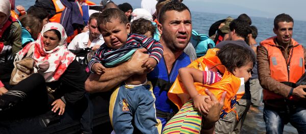 Syrian refugees arrive aboard a dinghy after crossing from Turkey to the island of Lesbos, Greece, Thursday, Sept. 10, 2015. The US is making plans to accept 10,000 Syrian refugees in the coming budget year Syrian refugees arrive aboard a dinghy after crossing from Turkey to the island of Lesbos, Greece, Thursday, Sept. 10, 2015. The US is making plans to accept 10,000 Syrian refugees in the coming budget year - Sputnik International