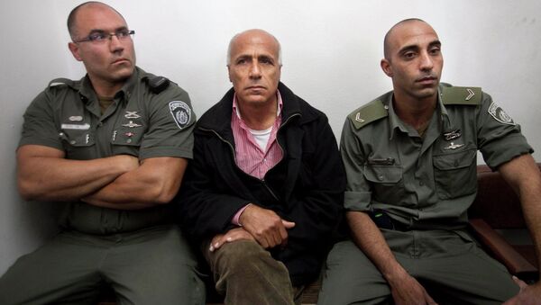 Israeli nuclear whistleblower Mordechai Vanunu, center, sits between two prison guards as he waits in a courtroom before a hearing in Jerusalem in 2009. - Sputnik International