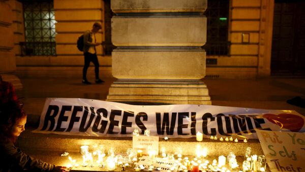 A woman lights a candle during a vigil for refugees in Nottingham, Britain, September 7, 2015 - Sputnik International