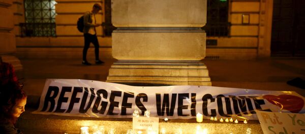 A woman lights a candle during a vigil for refugees in Nottingham, Britain, September 7, 2015 A woman lights a candle during a vigil for refugees in Nottingham, Britain, September 7, 2015 - Sputnik International