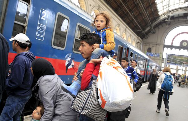 Migrants, who mostly crossed into the country from Serbia and are hoping to make their way to Austria, prepares to board a train heading to Hegyeshalom, at Keleti station in Budapest, Hungary, September 12, 2015 Migrants, who mostly crossed into the country from Serbia and are hoping to make their way to Austria, prepares to board a train heading to Hegyeshalom, at Keleti station in Budapest, Hungary, September 12, 2015 - Sputnik International