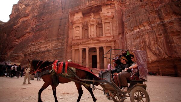 In this Thursday, March 6, 2014 photo, a horse carriage carries tourists for a tour at the Treasury in the ancient city of Petra, Jordan. - Sputnik International