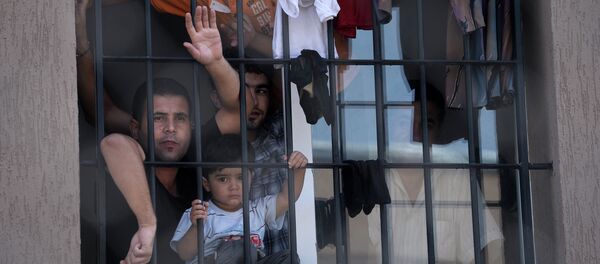 Refugees behind a barred window at Bulgaria's shelter for clandestine migrants near Lyubimets, as the small EU state finds it hard to cope with an ever rising number of Syrians fleeing conflict at home - Sputnik International