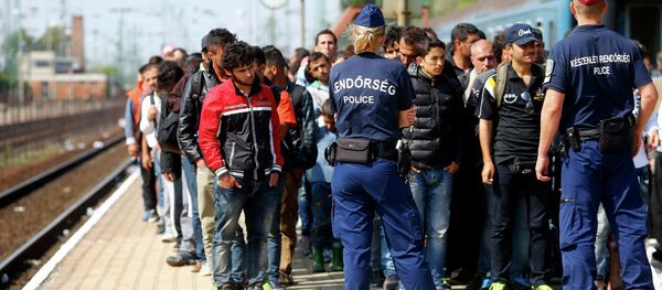 Hungarian police officers stand guard as migrants disembark from a train at the railway station in the town of Hegyeshalom next to the Austrian Hungarian border, Hungary September 13, 2015 Hungarian police officers stand guard as migrants disembark from a train at the railway station in the town of Hegyeshalom next to the Austrian Hungarian border, Hungary September 13, 2015 - Sputnik International