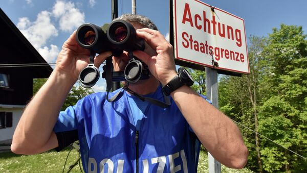 A policeman uses binoculars to secure the area on the Ederkanzel viewing platform near Mittenwald at the German-Austrian border on June 3, 2015 - Sputnik International