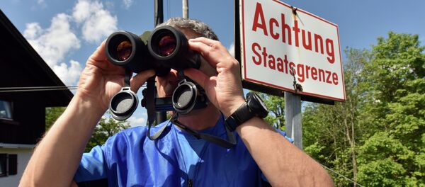 A policeman uses binoculars to secure the area on the Ederkanzel viewing platform near Mittenwald at the German-Austrian border on June 3, 2015 A policeman uses binoculars to secure the area on the Ederkanzel viewing platform near Mittenwald at the German-Austrian border on June 3, 2015 - Sputnik International