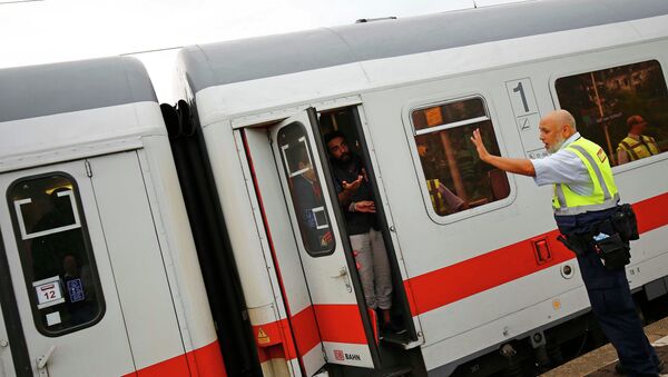 A security official of German rail operator Deutsche Bahn (DB) prevents migrants to disembark from their train at the main railway station in Frankfurt, Germany, September 13, 2015 - Sputnik International