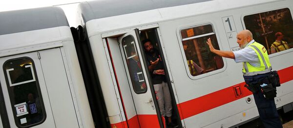 A security official of German rail operator Deutsche Bahn (DB) prevents migrants to disembark from their train at the main railway station in Frankfurt, Germany, September 13, 2015 - Sputnik International