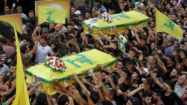 Mourners carry the coffins of two members of Lebanon's Shiite Hezbollah movement who were killed in combat alongside Syrian government forces fighting against Islamic State group jihadists in Syria's Qalamun region boarding Lebanon, during their funeral procession in a southern suburb of Beirut, on September 11, 2015 - Sputnik International
