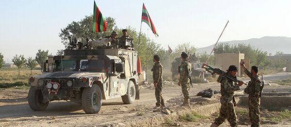 Afghan national army stand guard near the dead body of a Taliban attacker in front of the main prison building after an attack in Ghazni province, eastern Afghanistan, Monday, Sept. 14, 2015 - Sputnik International