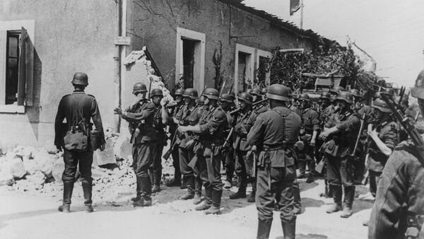 Storm troopers follow up the retreating enemy. The unit leader gives his men directions at a street crossing in Aisne, France on August 20, 1940 - Sputnik International