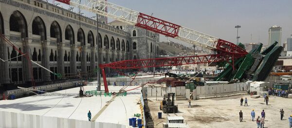 Muslim pilgrims walk near a construction crane which crashed in the Grand Mosque in the Muslim holy city of Mecca, Saudi Arabia September 12, 2015 - Sputnik International