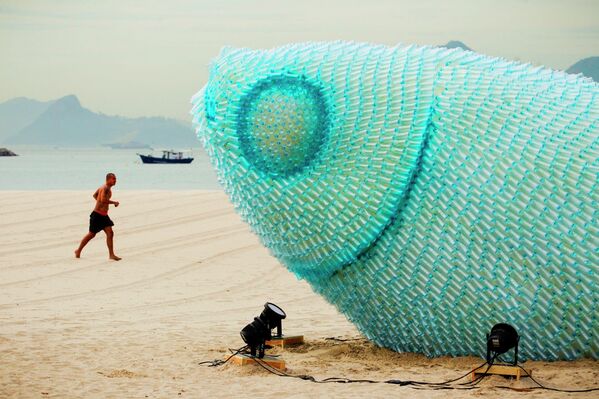 A man runs on Botafogo beach near a huge sculpture made from plastic bottles in Rio de Janeiro, Brazil. - Sputnik International