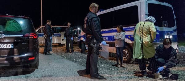 A police woman controls a refugee mother and her daughter at the German-Austrian border near Piding, southern Germany, on September 14, 2015 A police woman controls a refugee mother and her daughter at the German-Austrian border near Piding, southern Germany, on September 14, 2015 - Sputnik International