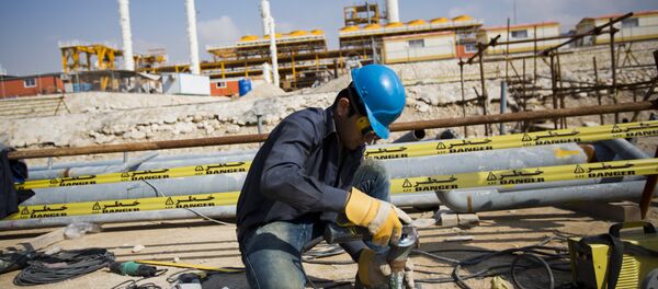 An Iranian man works at the phase 19 of the South Pars gas field facilities near the southern town of Kangan on the shore of the Gulf on January 22, 2014 - Sputnik International