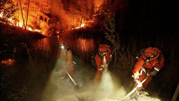 Firefighters create a firebreak near a home in Middletown, Calif - Sputnik International