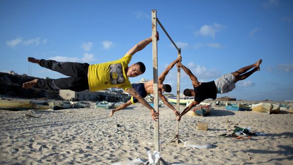Members of Bar Palestine, a street workout team practice their skills during a training session on the beach of Gaza City - Sputnik International