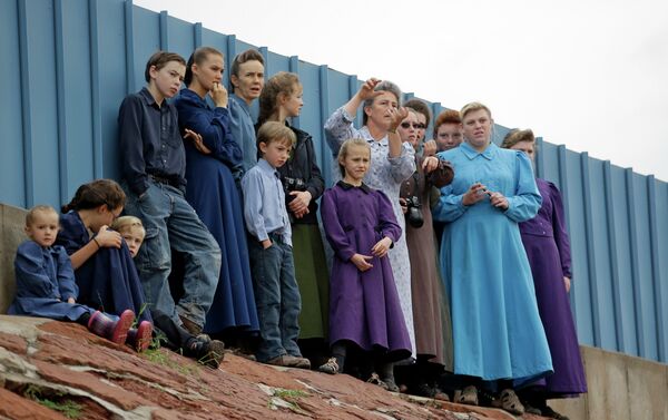 People look on as crews clear mud and debris from a road following the flash flood. People look on as crews clear mud and debris from a road following the flash flood. - Sputnik International