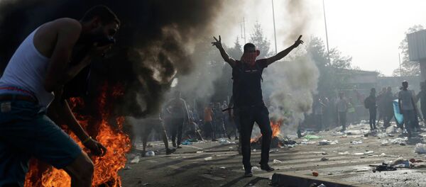 A migrant taunts Hungarian riot police as they fire tear gas and water cannon on the Serbian side of the border, near Roszke, Hungary September 16, 2015 - Sputnik International