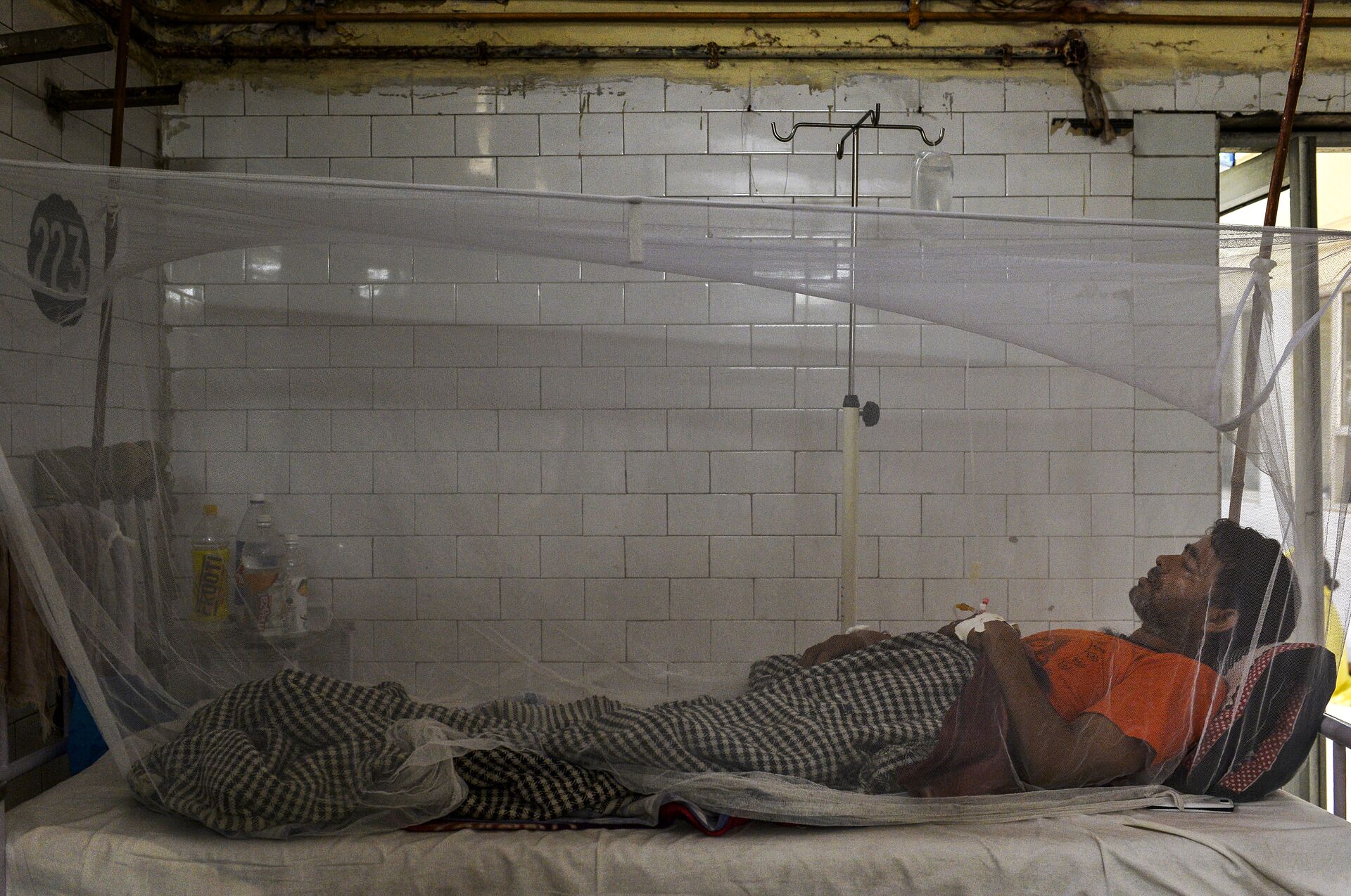 Indian patient lies in a bed covered with a mosquito net in a dengue ward of a government hospital in New Delhi - Sputnik International, 1920, 28.05.2022