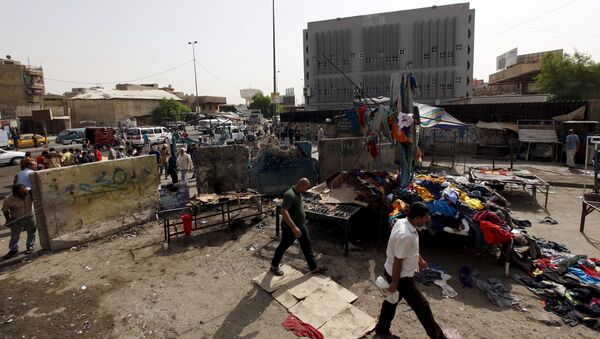Men walk past the site of a suicide bomb attack in Baghdad, Iraq - Sputnik International