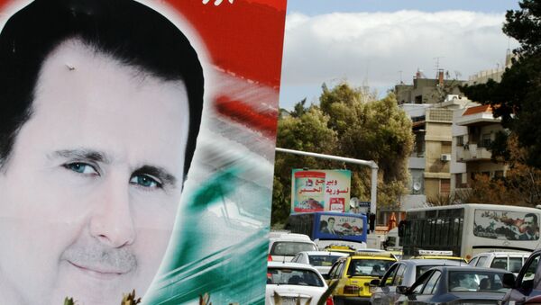 Banner bearing a portrait of Syrian President Bashar al-Assad in a street in the city of Damascus - Sputnik International