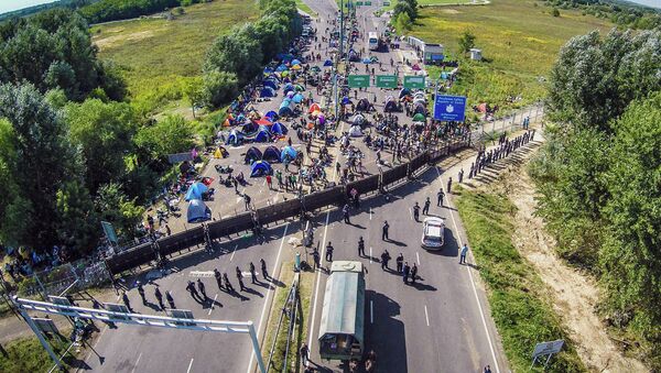 An aerial view taken on September 16, 2015 shows migrants camping on no-man's land of the border between Hungary and Serbia near Roeszke - Sputnik International
