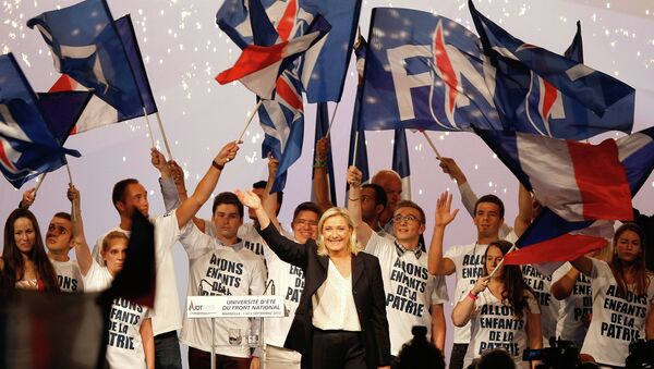 France’s far-right National Front president Marine Le Pen, center, surrounded by members, waves to supporters after her speech during their meeting in Marseille, southern France, Saturday, Sep. 6, 2015. - Sputnik International
