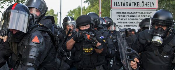 Hungarian riot police fight migrants at the border crossing with Serbia in Roszke, Hungary September 16, 2015 Hungarian riot police fight migrants at the border crossing with Serbia in Roszke, Hungary September 16, 2015 - Sputnik International