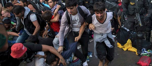 Migrants run as Hungarian riot police fires tear gas and water cannon at the border crossing with Serbia in Roszke, Hungary September 16, 2015. Migrants run as Hungarian riot police fires tear gas and water cannon at the border crossing with Serbia in Roszke, Hungary September 16, 2015. - Sputnik International