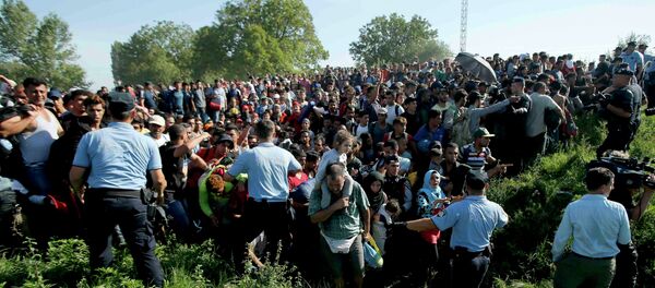 Policemen direct migrants during a stampede to board a bus in Tovarnik, Croatia September 17, 2015 Policemen direct migrants during a stampede to board a bus in Tovarnik, Croatia September 17, 2015 - Sputnik International