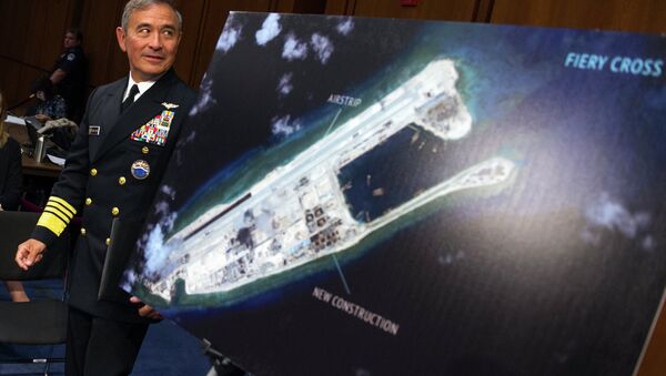 Adm. Harry B. Harris, Jr., US Navy Commander, U.S. Pacific Command walks past a photograph showing an island that China is building on the Fiery Cross Reef in the South China Sea - Sputnik International