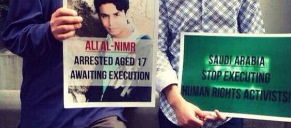 Demonstrators hold a picture of Ali Muhammed al-Nimr after his appeal case failed. - Sputnik International