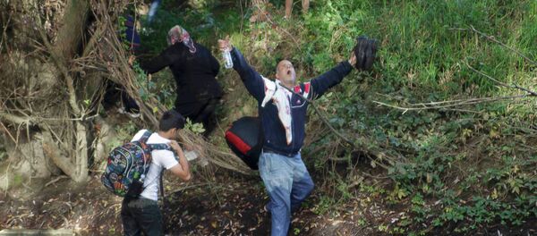 A migrant reacts after crossing the river Sutla near Senkovec, Croatia on their way to Slovenia September 18, 2015. A migrant reacts after crossing the river Sutla near Senkovec, Croatia on their way to Slovenia September 18, 2015. - Sputnik International