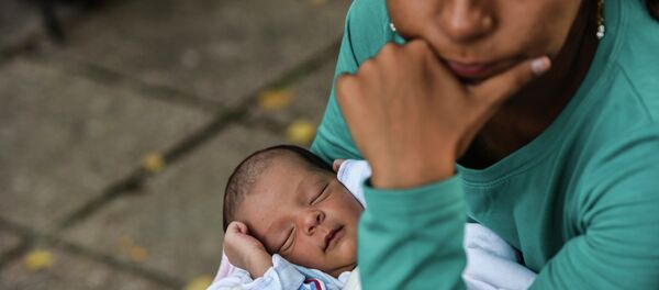 Seven-day-old Ali Taher, who was born on the Greek island of Lesbos, sleeps while his mother and other migrants take a break as they head towards the Serbia-Croatia border near the town of Bezdan on September 17, 2015. - Sputnik International