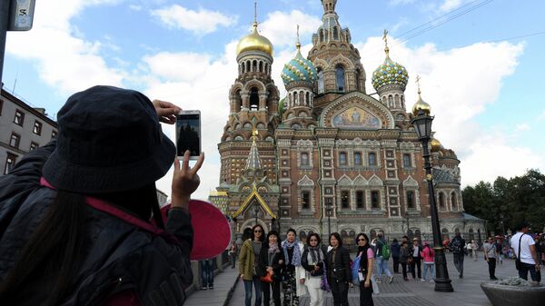 A picture taken on September 4, 2015 shows Chinese tourists as they have their photo taken in front of Church of the Savior on Blood  in central St. Petersburg. Drawn by its Communist past and a visa-free regime, Chinese tourists are flocking to Russia in droves as it develops new routes touting red tourism - Sputnik International