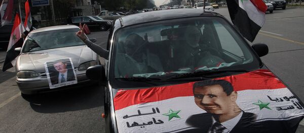 Syrians display national flags and banners with photos of Syrian President Bashar Assad. Syrians display national flags and banners with photos of Syrian President Bashar Assad. - Sputnik International