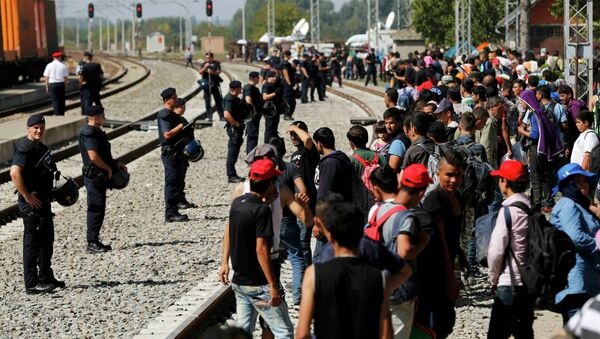 Police form a line in front of migrants at the railway station in Tovarnik, Croatia September 18, 2015 - Sputnik International
