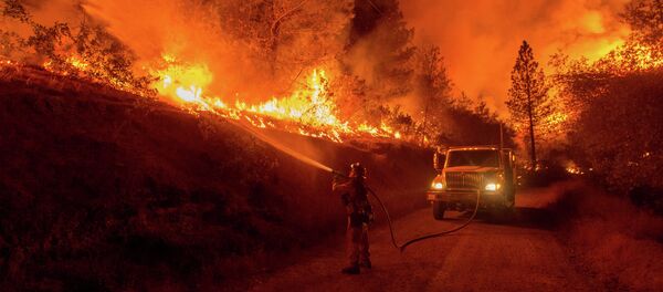 A firefighter douses flames from a backfire while battling the Butte fire near San Andreas, California on September 12, 2015 - Sputnik International