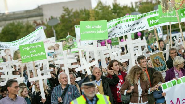 Supporters of christian group Pro Life carry crosses and hold a banner that reads (L) Unborn are no commodity as they protest against abortion in Berlin, Germany on September 21, 2013 - Sputnik International