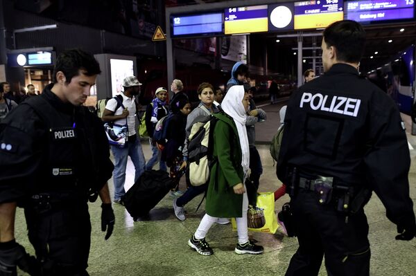 Syrian refugees and migrants are escorted to be registred by German police officers upon arrival from Austria at the Munich's main train station late September 3, 2015. Syrian refugees and migrants are escorted to be registred by German police officers upon arrival from Austria at the Munich's main train station late September 3, 2015. - Sputnik International
