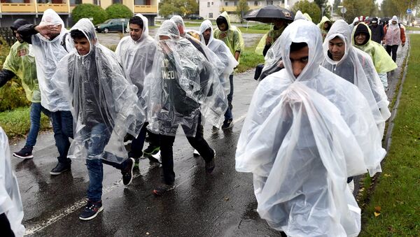 Refugees walked in heavy rain from a public transport centre to Lappia-building refugee reception centre in Tornio, northwestern Finland, September 18, 2015 - Sputnik International