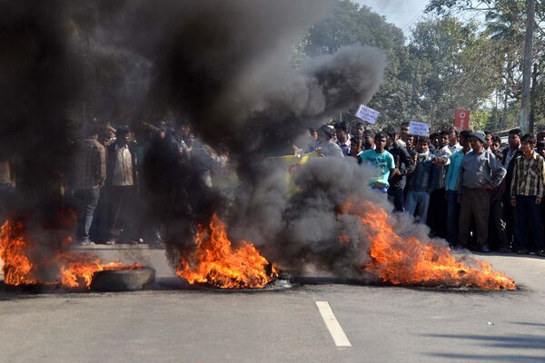 Activists of the Assam Tea Tribes Student Association (ATTSA) block the NH-52 road with burning tyres during a protest against the attacks on villagers by militants from the outlawed National Democratic Front of Bodoland (NDFB) in four locations, at Baghmari in the Sonitpur district of northeastern Assam state on December 24, 2014 Activists of the Assam Tea Tribes Student Association (ATTSA) block the NH-52 road with burning tyres during a protest against the attacks on villagers by militants from the outlawed National Democratic Front of Bodoland (NDFB) in four locations, at Baghmari in the Sonitpur district of northeastern Assam state on December 24, 2014 - Sputnik International