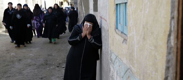 A woman mourns for the Egyptian Coptic Christians captured in Libya and killed by militants affiliated with the Islamic State group, outside of the Virgin Mary church in the village of el-Aour, near Minya, 220 kilometers (135 miles) south of Cairo, Egypt, Monday, Feb. 16, 2015 - Sputnik International