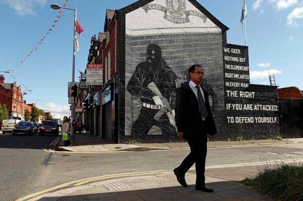 A man walks past a mural in East Belfast in Northern Ireland, September 18, 2015 A man walks past a mural in East Belfast in Northern Ireland, September 18, 2015 - Sputnik International