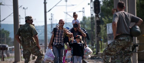 Migrants and refugees cross the Macedonian-Greek border near Gevgelija on September 20, 2015 Migrants and refugees cross the Macedonian-Greek border near Gevgelija on September 20, 2015 - Sputnik International